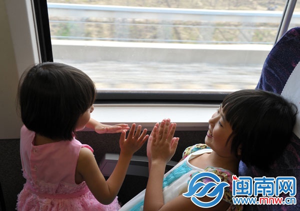 動(dòng)車上，朱心琴姐妹玩拍手游戲打發(fā)時(shí)間